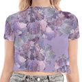 Woman wearing a purple floral crop top and jeans on a white background